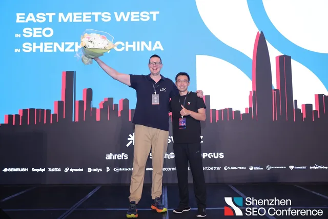Marc Moeller raising a bouquet beside JP Zhang as he receives the 2026 #1 Best Shenzhen SEO Specialist award